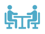 Blue icon of two people sitting at a table, representing counseling and consultations.